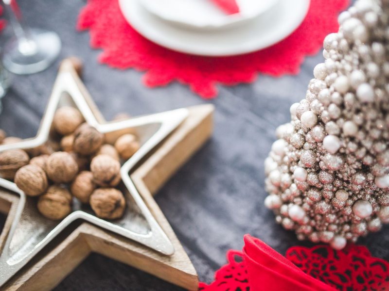 Nozes numa travessa em forma de estrela, sobre uma mesa decorada para o Natal