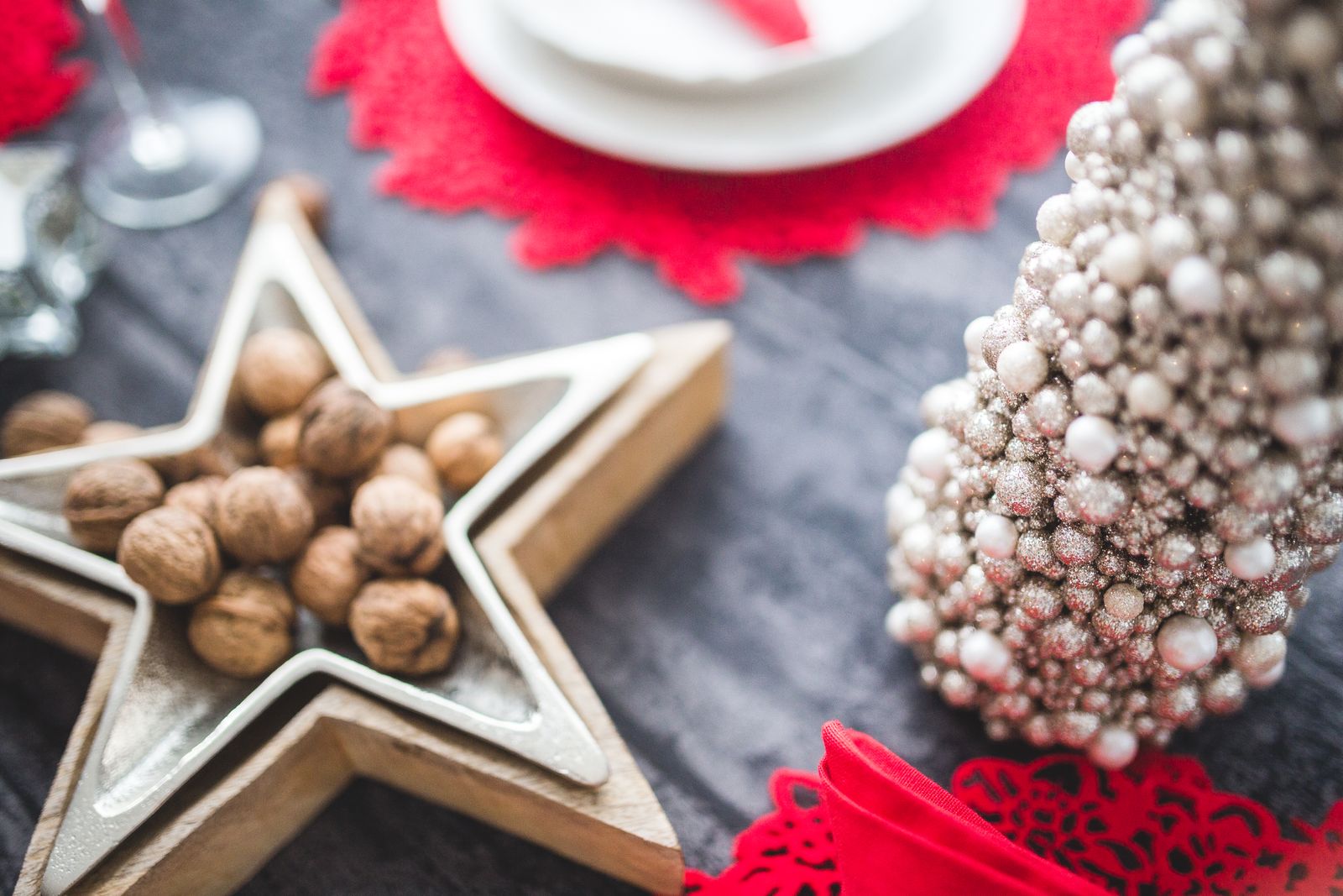 Nozes numa travessa em forma de estrela, sobre uma mesa decorada para o Natal