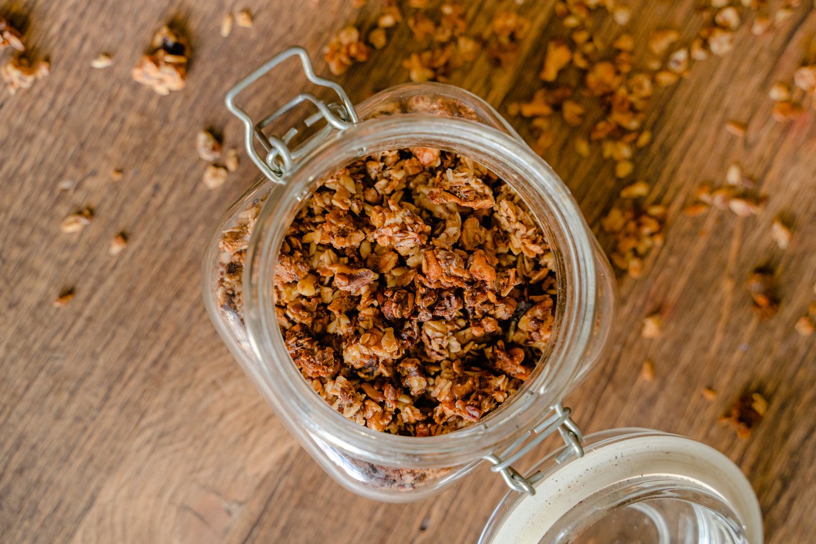 Granola caseira num frasco de vidro sobre uma mesa de madeira